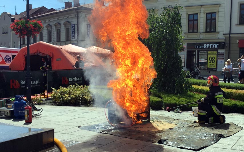Strażacy na rynku pokazują, czemu nie gasić płonącego oleju wodą